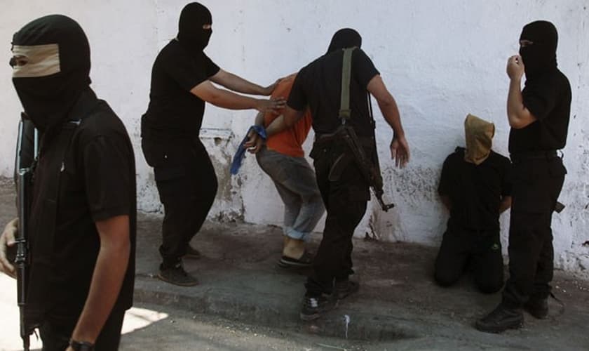 Militantes do Hamas cercam palestinos acusados de terem colaborado com Israel nesta sexta-feira(22); 18 foram mortos 