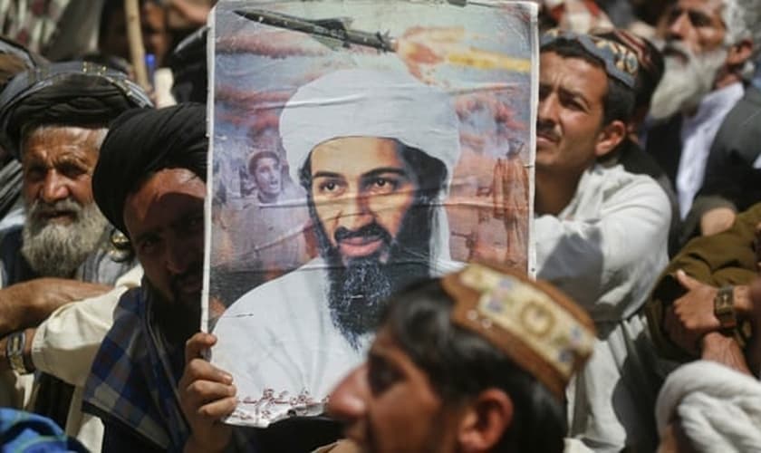 Apoiador do grupo extremista paquistanês 'Jamiat-e-ulema-e-Islam' segura cartaz com foto do ex-líder da al-Qaeda, Osama bin Laden, durante manifestação contra a ação dos Estados Unidos no Oriente Médio