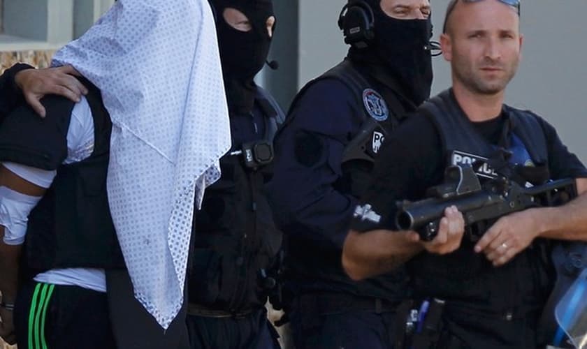 Com a cabeça coberta por uma camisa, Yassin Salhi é levado pela polícia francesa