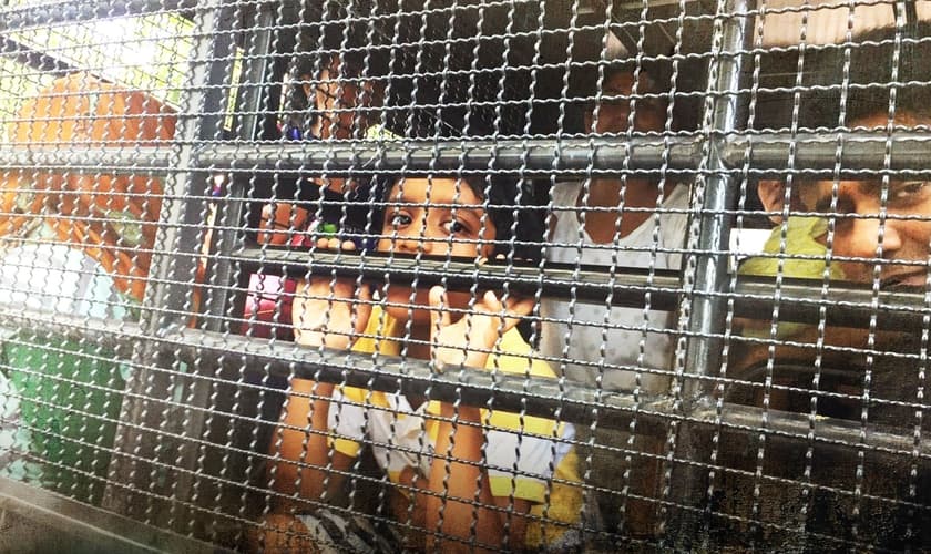 Crianças e adultos refugiados são colocados em gaiolas na Tailândia. (Foto: CBN)