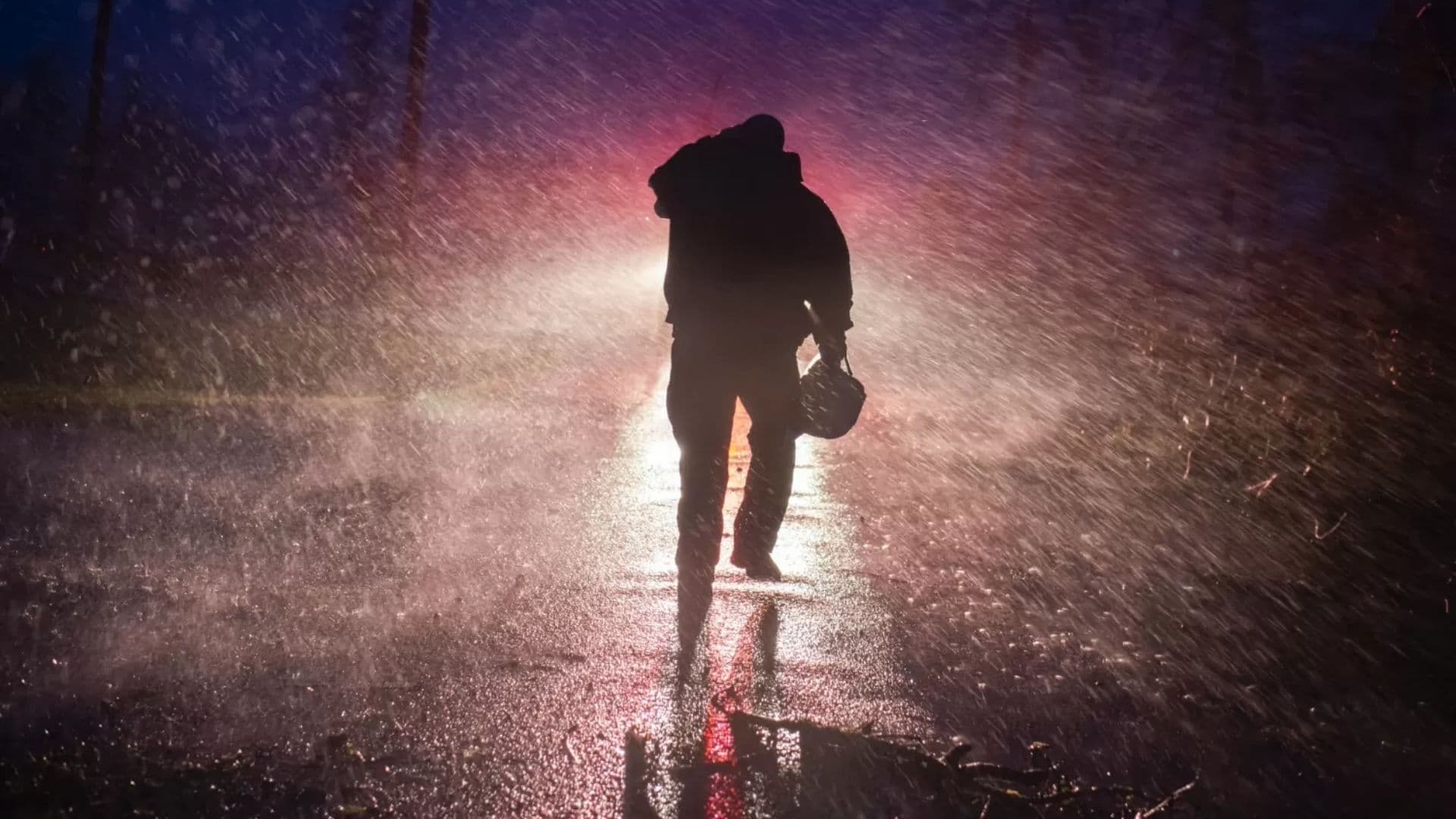 Um chefe de bombeiros voltando para o seu caminhão, na chuva, em Louisiana, depois da passagem do furacão Ida. (Foto: Mark Felix/AFP)