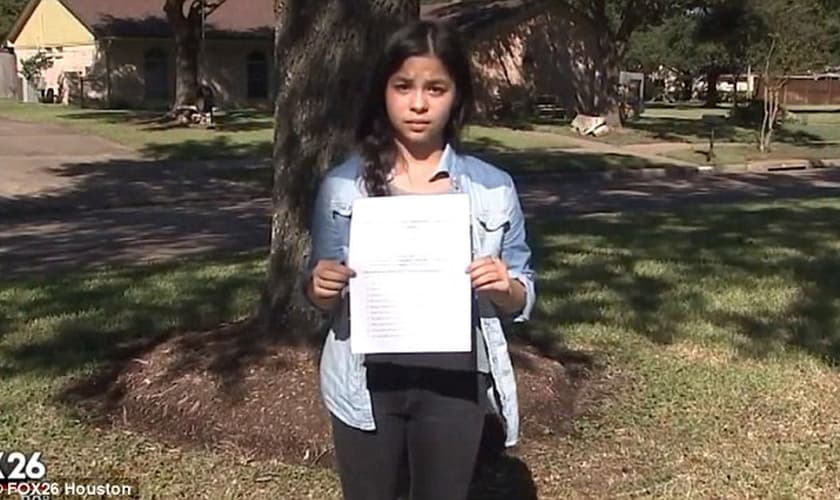 A estudante Jordan Wooley exibe a folha com a atividade polêmica, que exigia que ela afirmasse que "Deus é um mito". (Imagem: Fox 26)