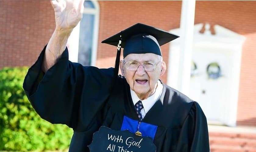 No dia de sua formatura, o pastor segurava uma placa que dizia: "Com Deus todas as coisas são possíveis - Mateus 19:26" (Foto: Reprodução).