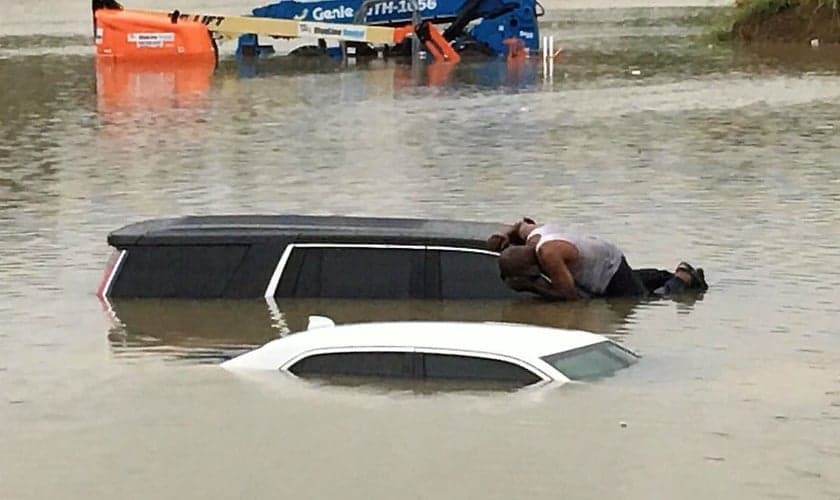 Pastor se arrisca sobre carros em meio à enchente que tem devastado Houston e outras regiões do Texas. (Foto: Facebook - Brian Roberson)