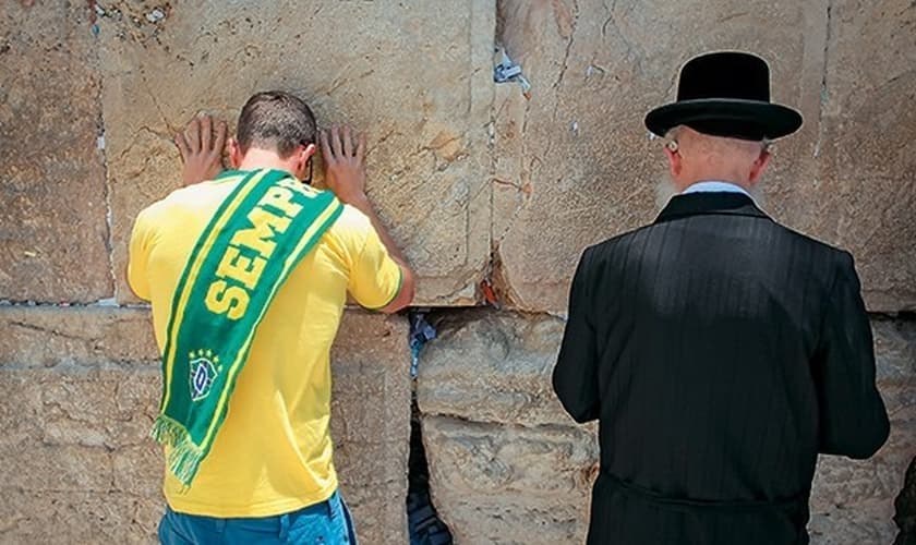 Brasileiro ora ao lado de judeu no Muro das Lamentações. (Foto: Época)