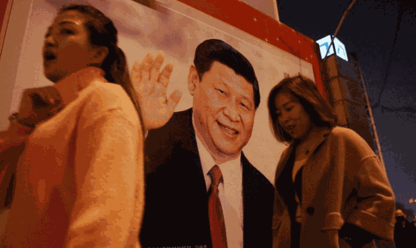 Pessoas passam por foto do presidente Xi-Jinping, exposta em rua da China. (Foto: Breitbart)