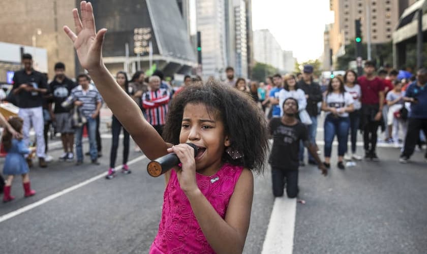 Aos 10 anos, Vitória de Deus canta e prega na Avenida Paulista. (Foto: Eduardo Knapp/Folhapress)