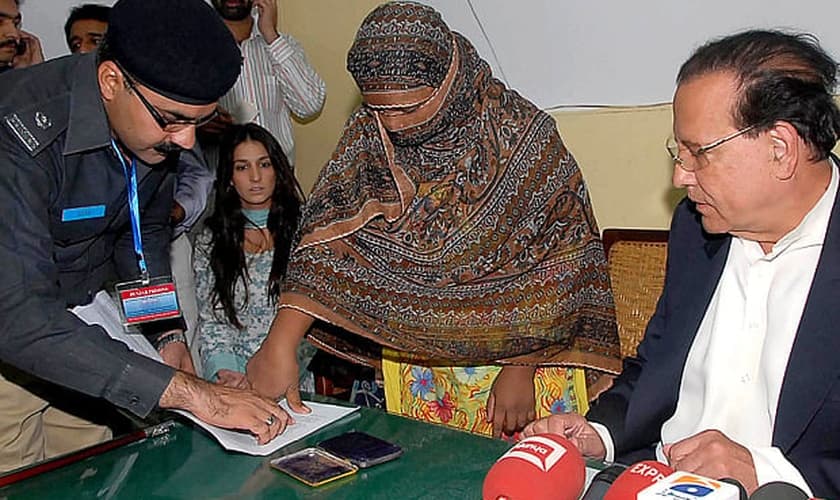 Asia Bibi coloca sua digital em um documento de recurso contra a condenação de sentença de morte. (Foto: AFP)