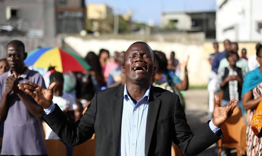 Cristãos durante culto depois que sua igreja foi destruída pelo ciclone Idai, em Moçambique. (Foto: Reuters/Siphiwe Sibeko)