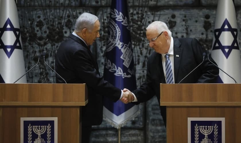 Benjamin Netanyahu aperta a mão do presidente de Israel, Reuven Rivlin. (Foto: Menahem Kahana/AFP)
