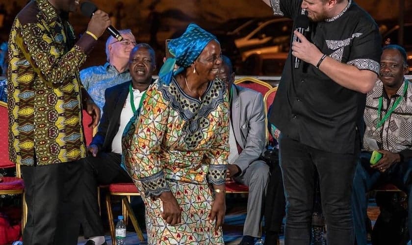 Mulher que se rastejava fica de pé e começa a andar durante Conferência Fire, no Togo. (Foto: Reprodução/O. Volyk)