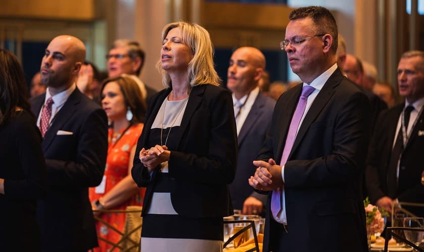 Pastor Andrew Brunson (primeiro plano à direita) e sua esposa Norine (primeiro plano do centro) oraram com líderes em um jantar de 1º de maio, antes do Dia Nacional de Oração. (Foto: Reprodução/John Phillips)