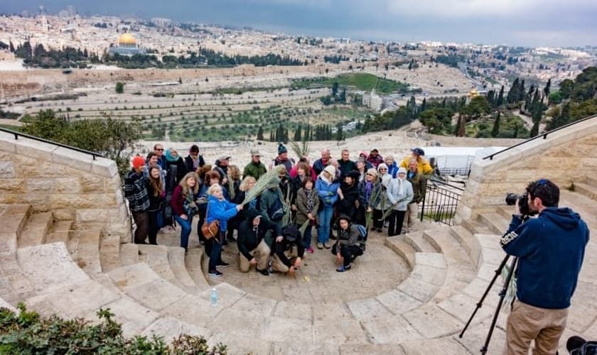 Grupo de turistas tira foto no Monte das Oliveiras, com a cidade velha de Jerusalém em segundo plano. (Foto: Shutterstock)