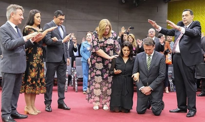 Jair Bolsonaro e sua esposa, Michelle, se ajoelham para que líderes orem pelo governo, durante culto da Assembleia de Deus, em Manaus. (Foto: BNC Amazonas)
