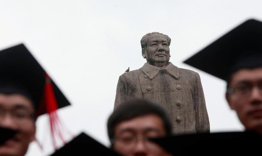 Graduados posam para foto em frente à estátua do líder chinês Mao Tsé Tung após sua cerimônia de formatura na Universidade de Fudan, em Xangai. (Foto: Aly Song/Reuters)