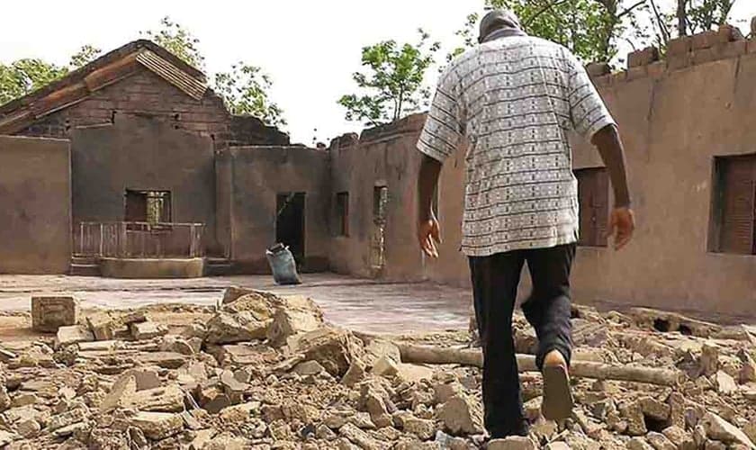 Cristão caminha por escombros de igreja incendiada na Nigéria. (Foto: Portas Abertas)