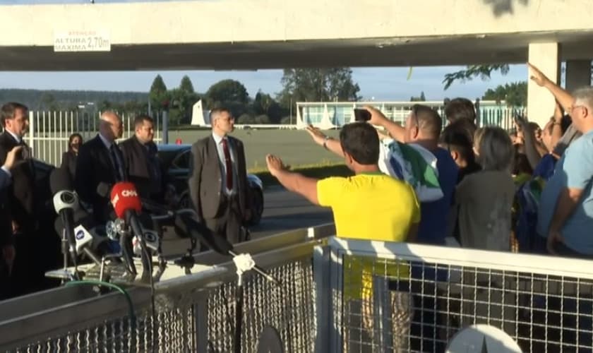 Apoiadores de Bolsonaro oram pelo presidente na porta do Palácio da Alvorada. (Foto: CNN)