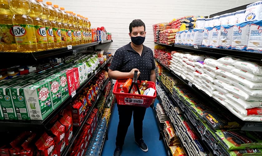Luander Oliveira, coordenador do Mercado Solidário, em meio às prateleiras com doações. (Foto: Rafaelly Machado)