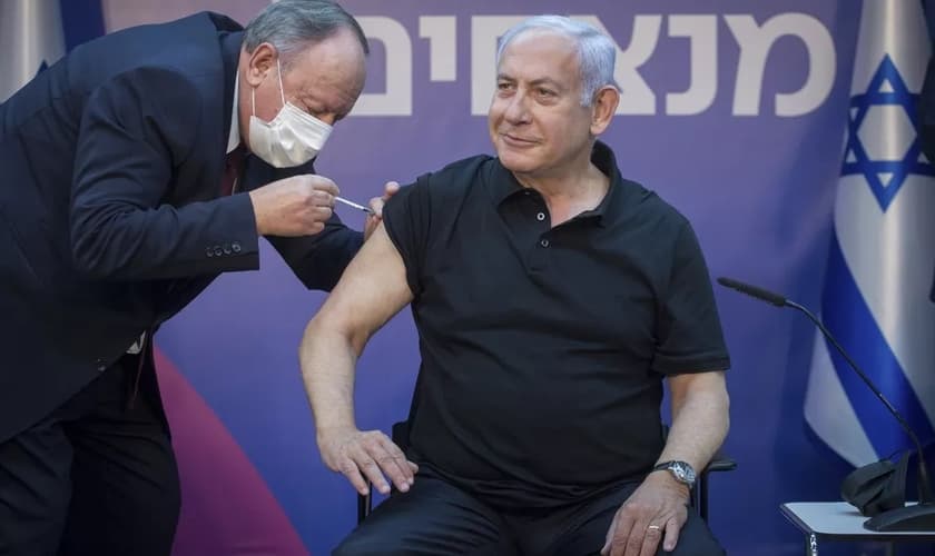Primeiro-ministro de Israel, Benjamin Netanyahu, recebe segunda dose da vacina da Pfizer-BioNTech contra a Covid-19 no dia 9 de janeiro. (Foto: Miriam Elster /Pool Photo via AP)