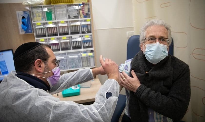 Homem recebe vacina da Covid-19 em posto de vacinação de Jerusalém, em 30 de dezembro de 2020. (Foto: Noam Revkin Fenton/Flash90)