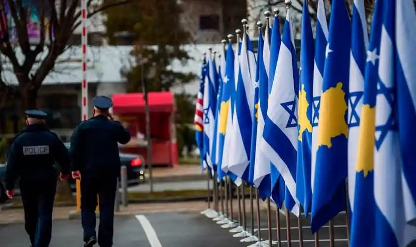 Policiais passam por bandeiras de Kosovo e Israel expostas durante uma cerimônia em Pristina em fevereiro, depois que os países estabeleceram relações diplomáticas. (Foto: Armend Nimani / AFP / Getty Images)