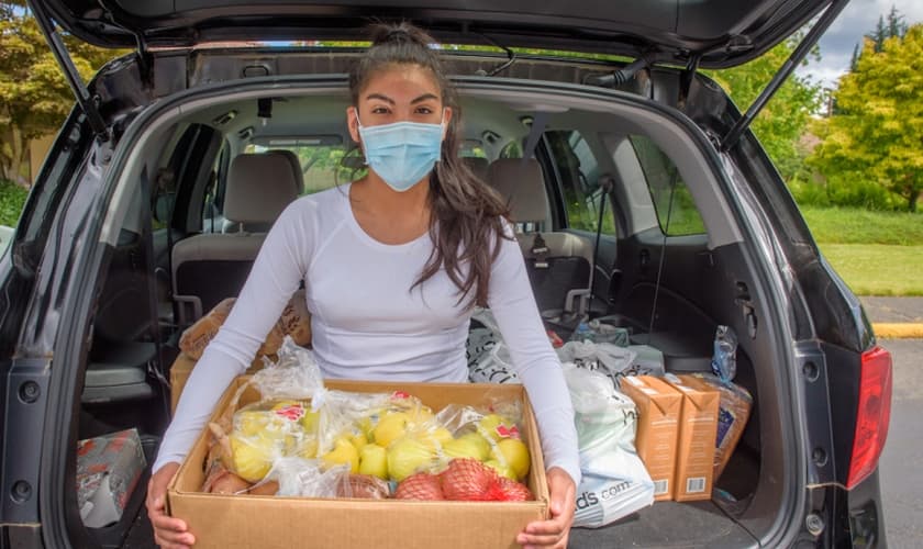 Diana Vergara possui uma caixa de alimentos frescos doada a sua família pela Visão Mundial na Igreja Adventista de Auburn City em Auburn, Washington. (Foto: Visão Mundial / Laura Reinhardt).