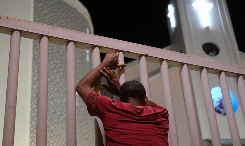 Homem do lado de fora de igreja fechada no Rio de Janeiro. (Foto: Ricardo Moraes/Reuters)