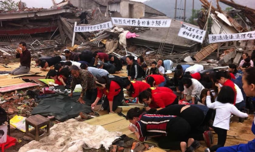 Cristãos se ajoelham nos escombros de uma igreja demolida . (Foto: Reprodução / China Aid)