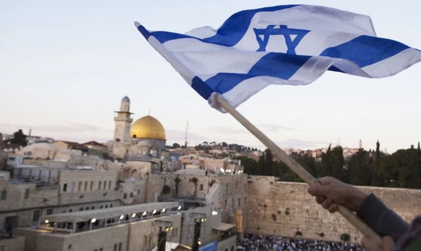Bandeira israelense sendo hasteada perto do Muro das Lamentações no Dia de Jerusalém, em 13 de maio. (Foto: Lior Mizrahi/Getty Images)