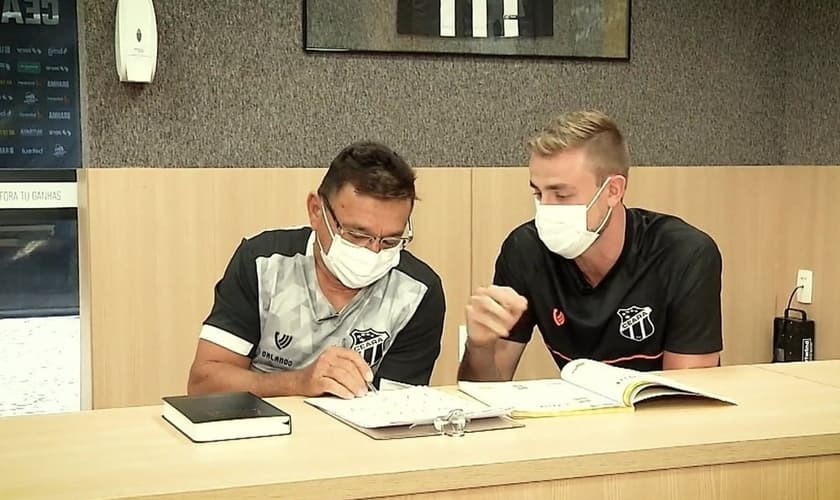 O jogador Klaus ensinando Seu Orlando a ler. (Foto: Reprodução / GE)