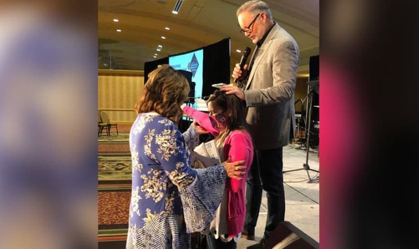 Rita DuBose (à esq.) e seu marido oram por Cassie Fawns durante culto. (Foto: AG News)