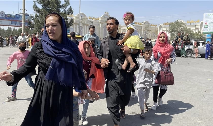 Uma família afegã corre para o Aeroporto Internacional Hamid Karzai enquanto foge da capital afegã, Cabul. (Foto: Haroon Sabawoon / Agência Anadolu)