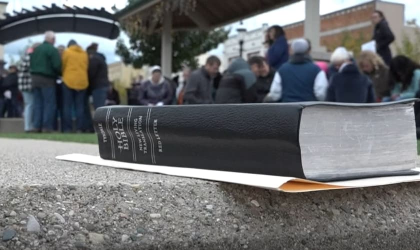 Membros da agência missionária em oração pelos 17 sequestrados. (Foto: Captura de tela/WZZM13).