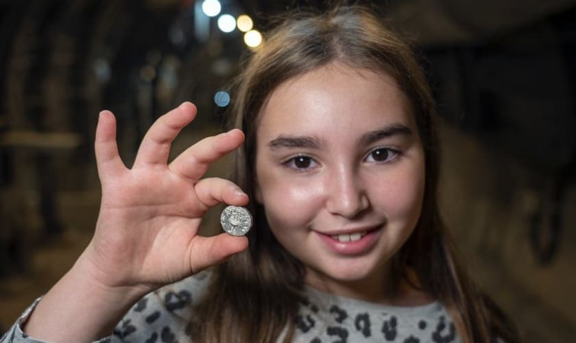 Liel Krutokop, de 11 anos, com a moeda que encontrou. (Foto: Yaniv Berman/Cidade de Davi e Autoridade de Antiguidades de Israel)