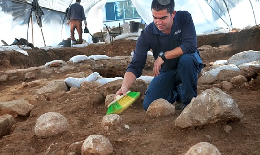 Kfir Arbiv, diretor de escavação da Autoridade de Antiguidades de Israel, limpa uma pedra balista no Complexo Russo. (Foto: Yoli Schwartz/Israel Antiquities Authority)