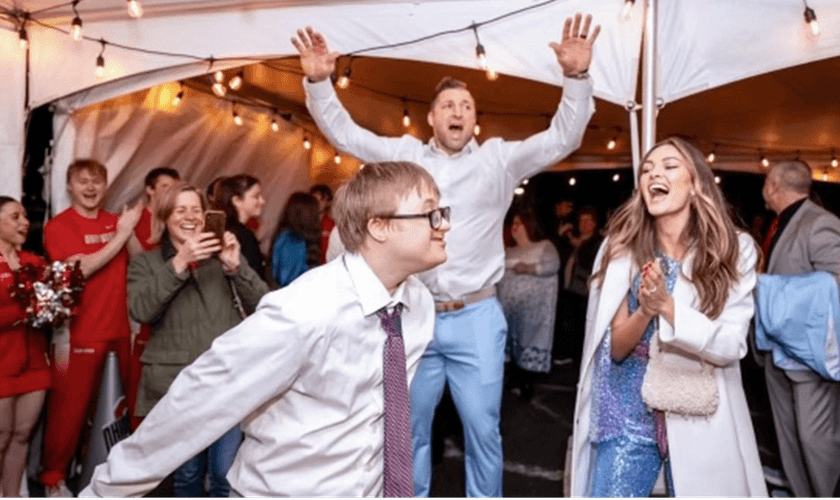 Participantes do evento Noite para Brilhar e Tim Tebow ao fundo. (Foto: X/Tim Tebow)